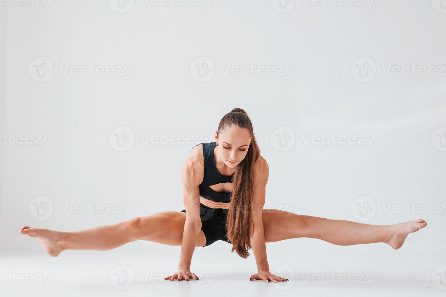 auf den Händen stehen. junge frau in sportlicher kleidung, die drinnen turnt foto