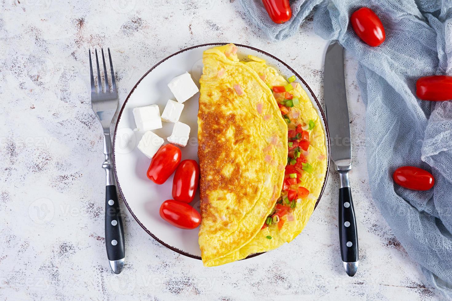 gebratenes Omelette mit Rindfleisch, Tomaten, Zwiebeln und Kräutern. leckeres Frühstück mit Rührei. Ansicht von oben foto