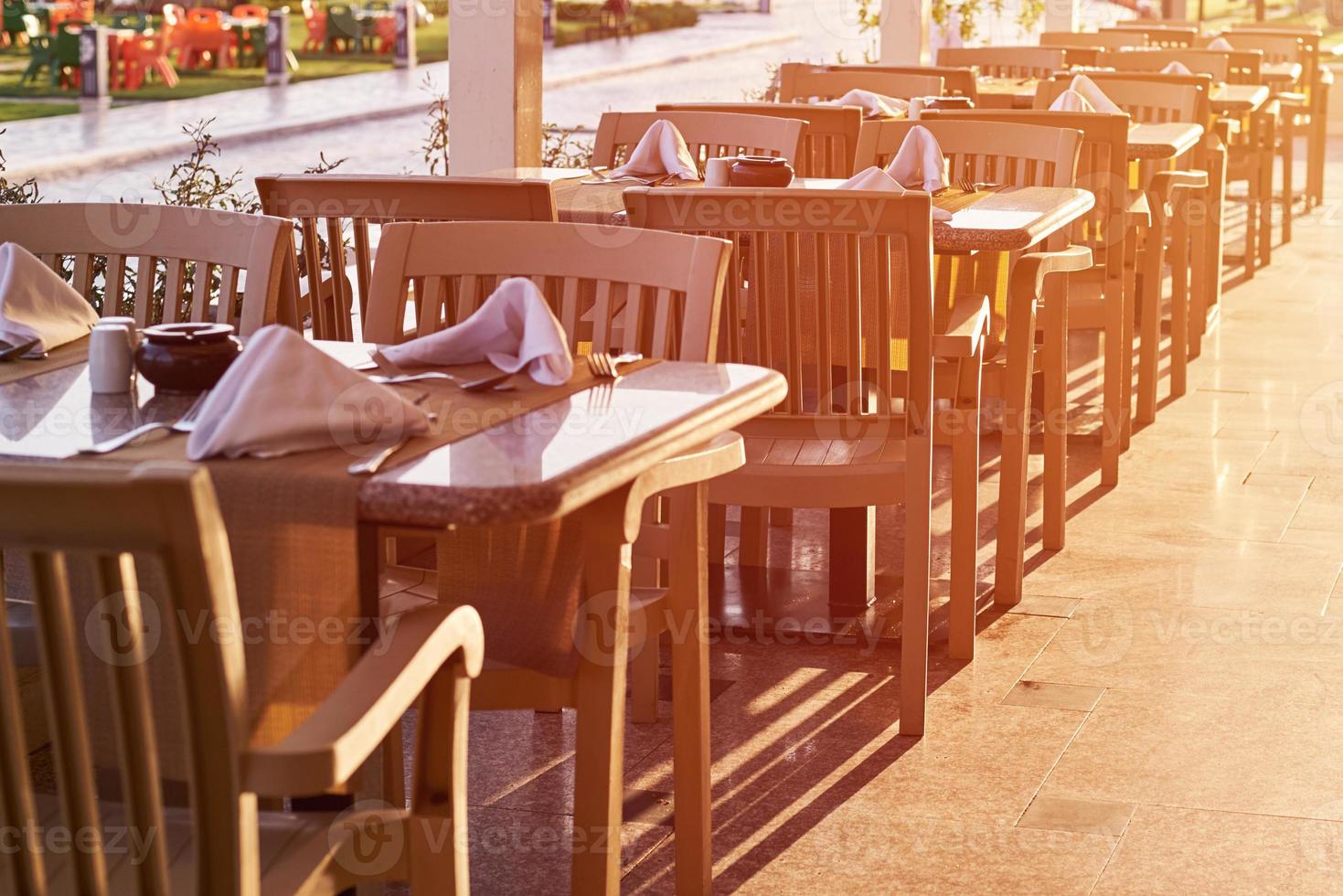 leere Terrasse mit Tisch und Stühlen im Freien bei Sonnenuntergang foto