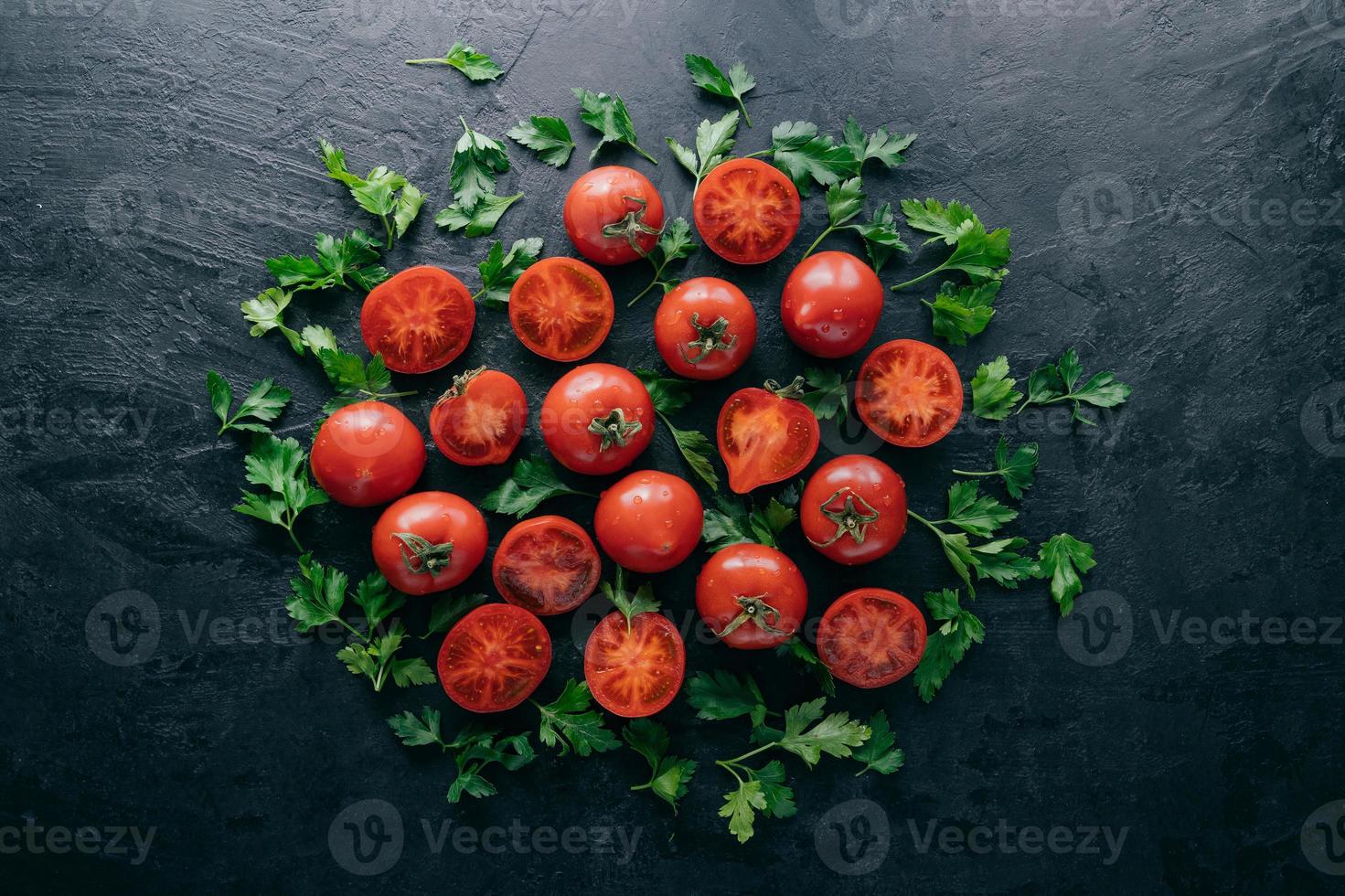 Schuss von roten reifen Tomaten und grüner frischer Petersilie auf dunklem Hintergrund. pflanzliche Zusammensetzung. gesundes ernährungskonzept. Bio-Lebensmittel foto