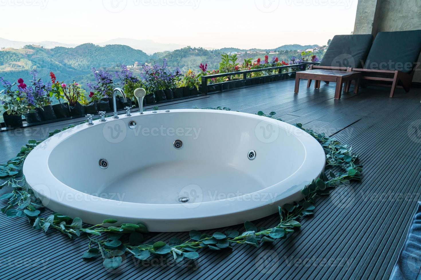 Badewanne auf dem Balkon mit Berghügelhintergrund foto
