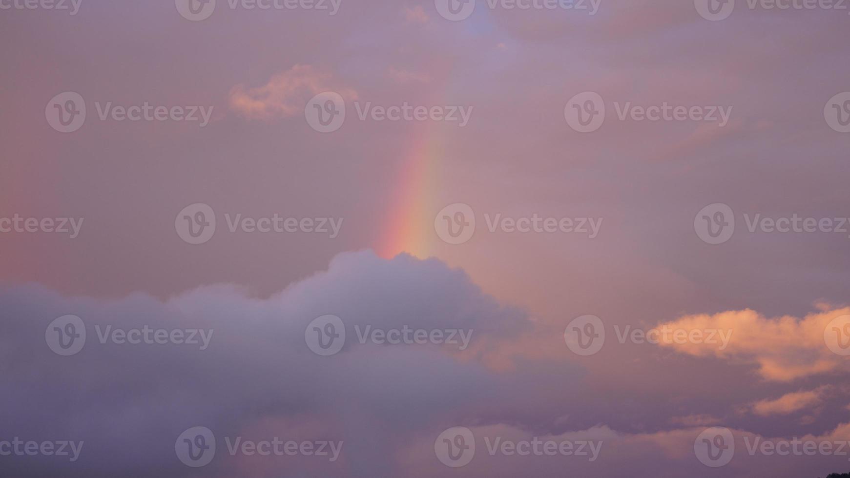 der bunte regenbogen, der nach dem sommerregen in den himmel aufsteigt foto