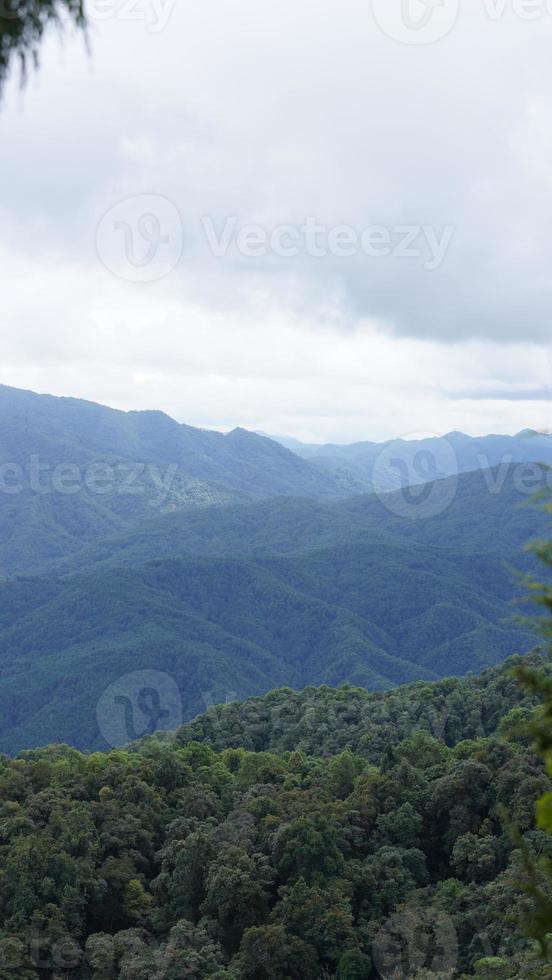 die schöne Aussicht auf die Berge mit dem bewölkten Himmel und dem Tal darunter foto