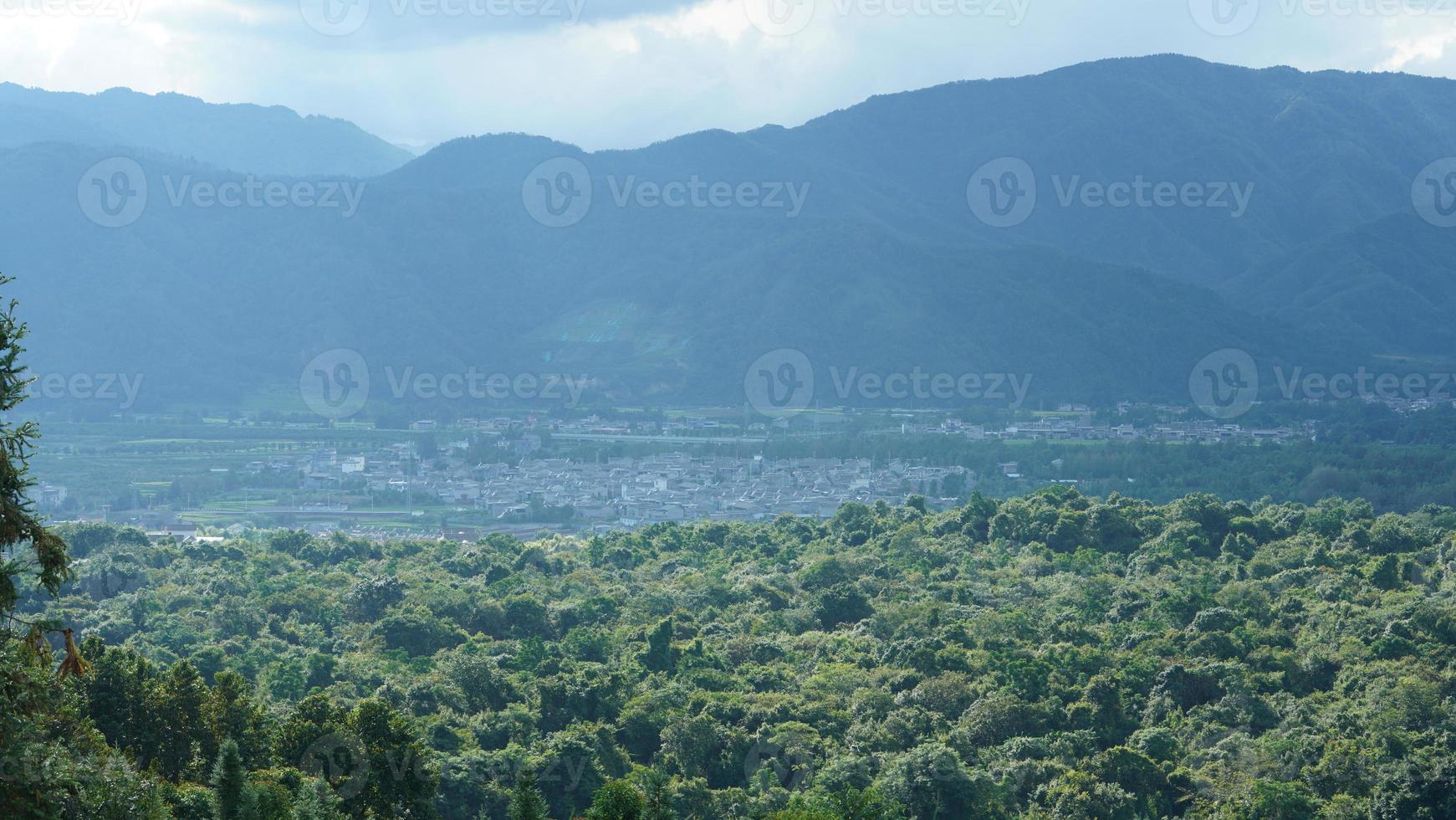 die schöne Aussicht auf die Berge mit dem bewölkten Himmel und dem Tal darunter foto