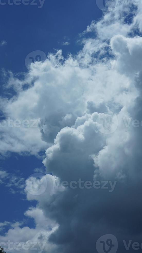 der Blick auf den blauen Himmel mit den weißen Wolken im Sommer foto