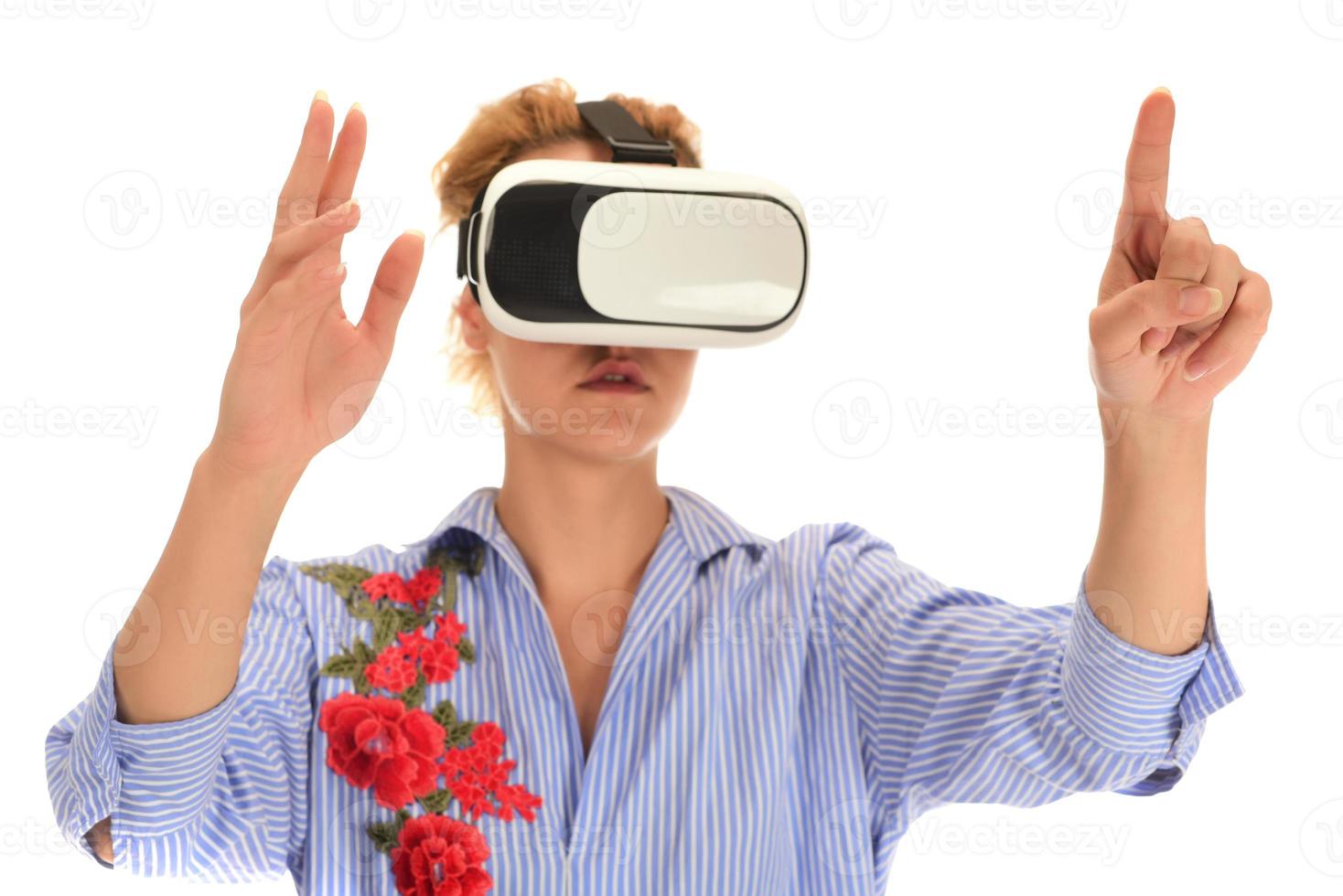 ziemlich schöne aufgeregte frau im vr-headset, die nach oben schaut und versucht, objekte in der virtuellen realität zu berühren foto