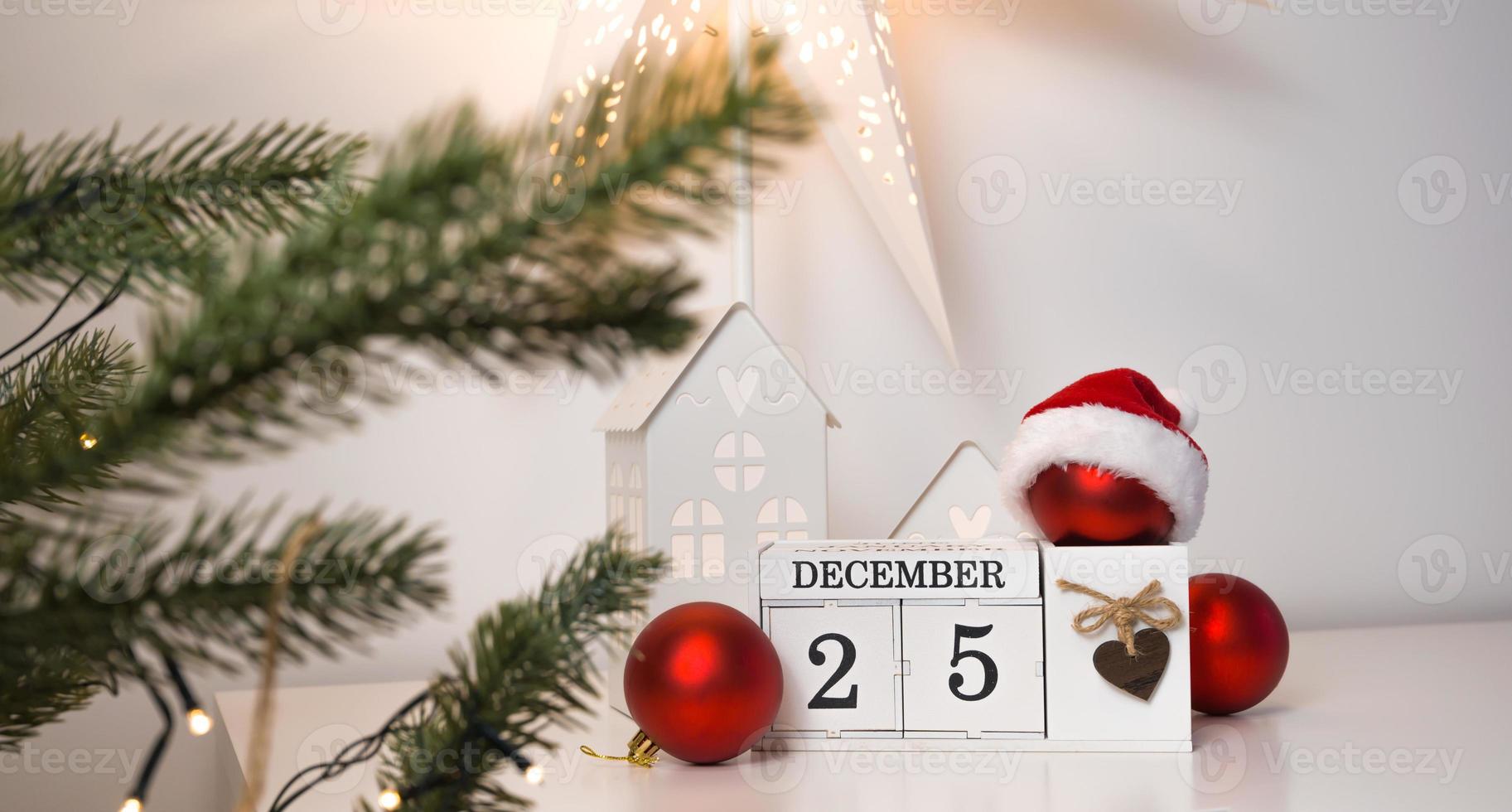 vinytage-kalender mit datum am 25. dezember in der nähe des weihnachtsbaums und einigen roten ornamenten foto