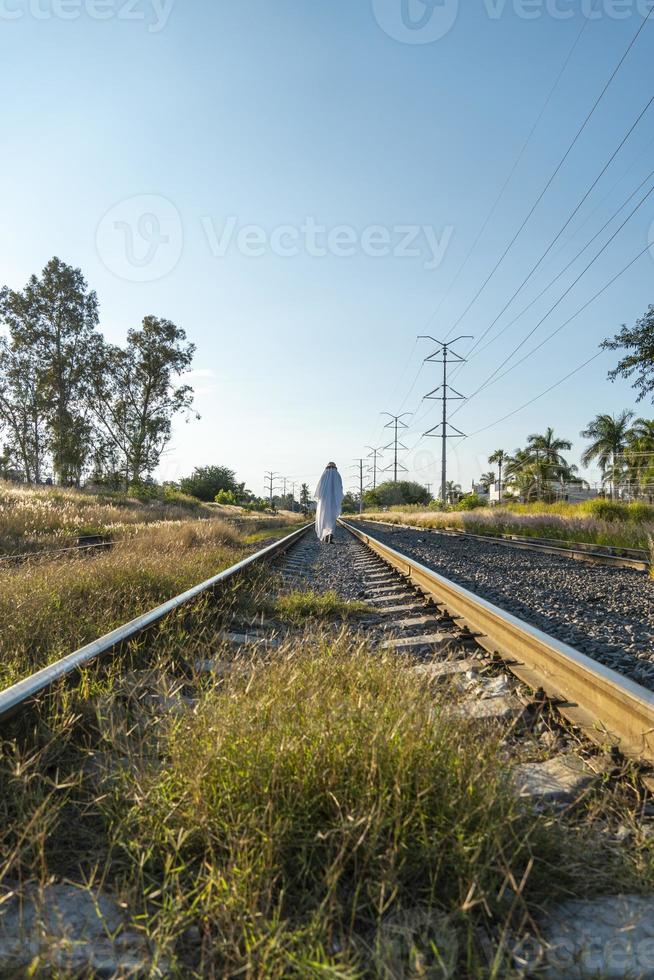 Gespenst auf Bahngleisen mit Zug, der hinterher fährt, bei Sonnenuntergang, Mexiko Lateinamerika foto