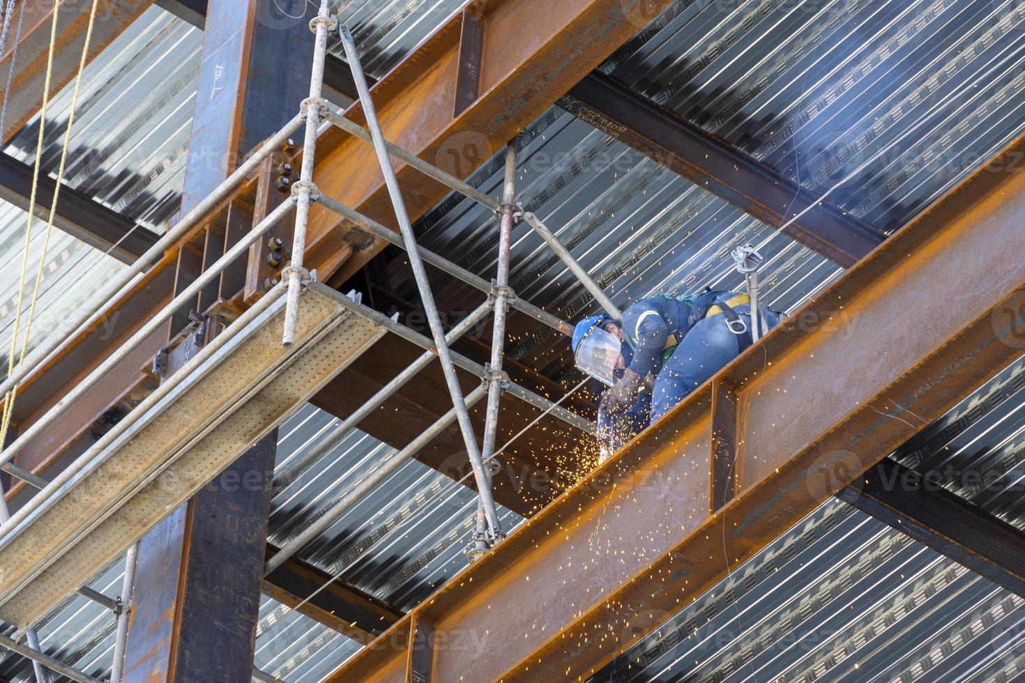 Verrostete Stahlkonstruktion, während ein Mann Fugen schweißt, Mexiko Guadalajara foto
