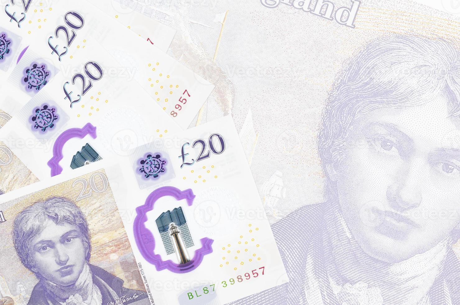 20 britische Pfund-Scheine liegen im Stapel auf dem Hintergrund einer großen halbtransparenten Banknote. abstrakter betriebswirtschaftlicher hintergrund foto