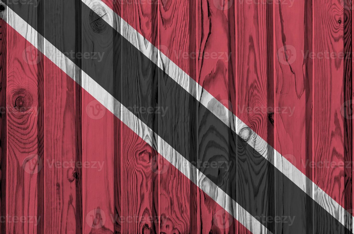 die flagge von trinidad und tobago ist in hellen farben auf einer alten holzwand dargestellt. strukturierte Fahne auf rauem Hintergrund foto