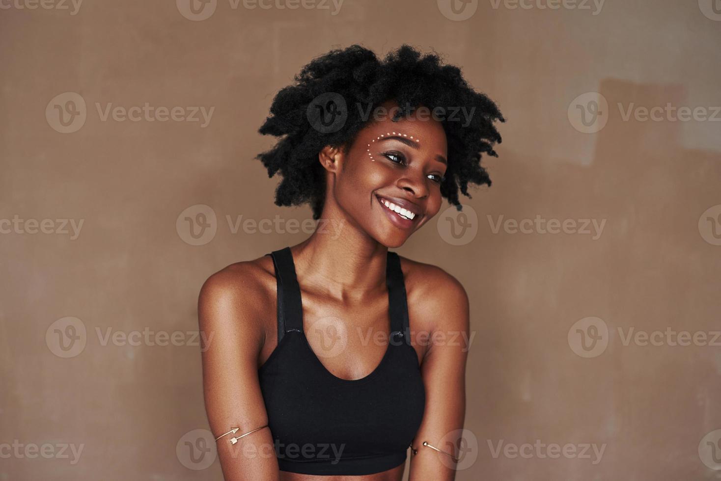 junge schöne Afro-Amerikanerin im Studio vor braunem Hintergrund foto