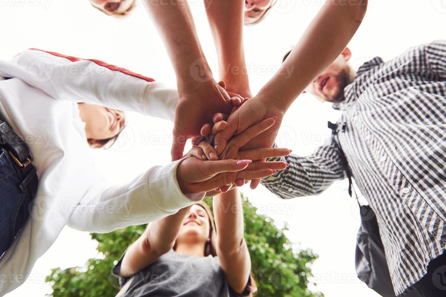 Nahaufnahme der Hände des jungen Teams erfolgreicher Freunde im Freien foto