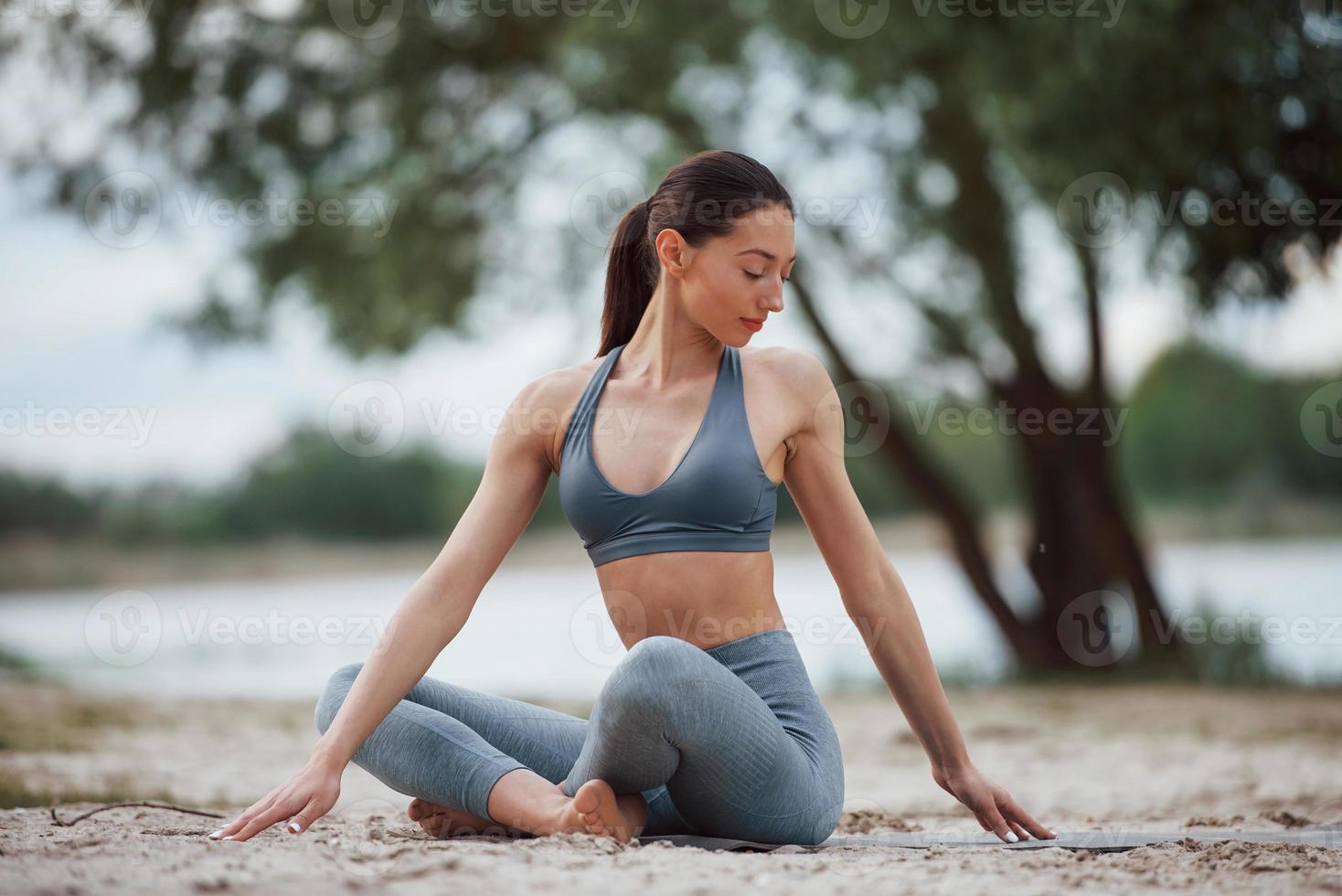 die heutige Arbeit gut gemacht. brünette mit schöner körperform in sportlicher kleidung haben einen fitnesstag am strand foto