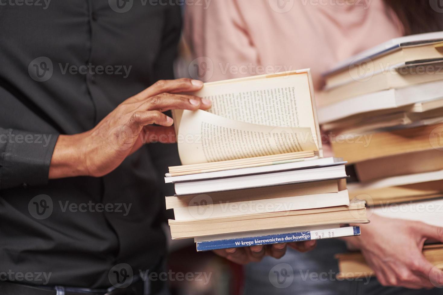 Konzeption von Bildung. gemischtrassige Studenten in der Bibliothek, die gemeinsam nach Informationen suchen foto