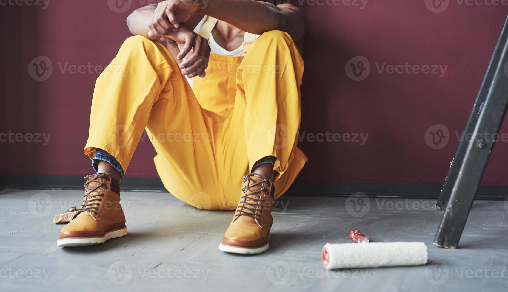 geerdete Sicht. junge afroamerikanische arbeiter in der gelben uniform haben einen job foto