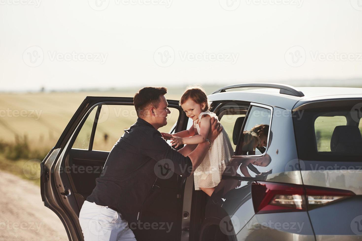 komm, geh raus. Schöne Menschen sitzen an ihren Wochenenden im modernen Auto foto