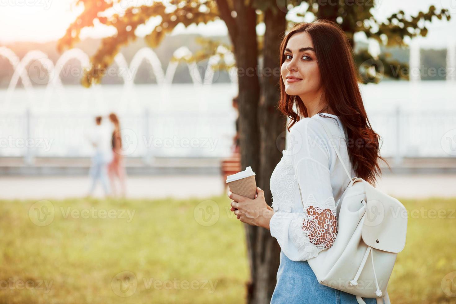 schöner Sonnenstrahl. junge frau hat an ihrem wochenende eine gute zeit im park foto