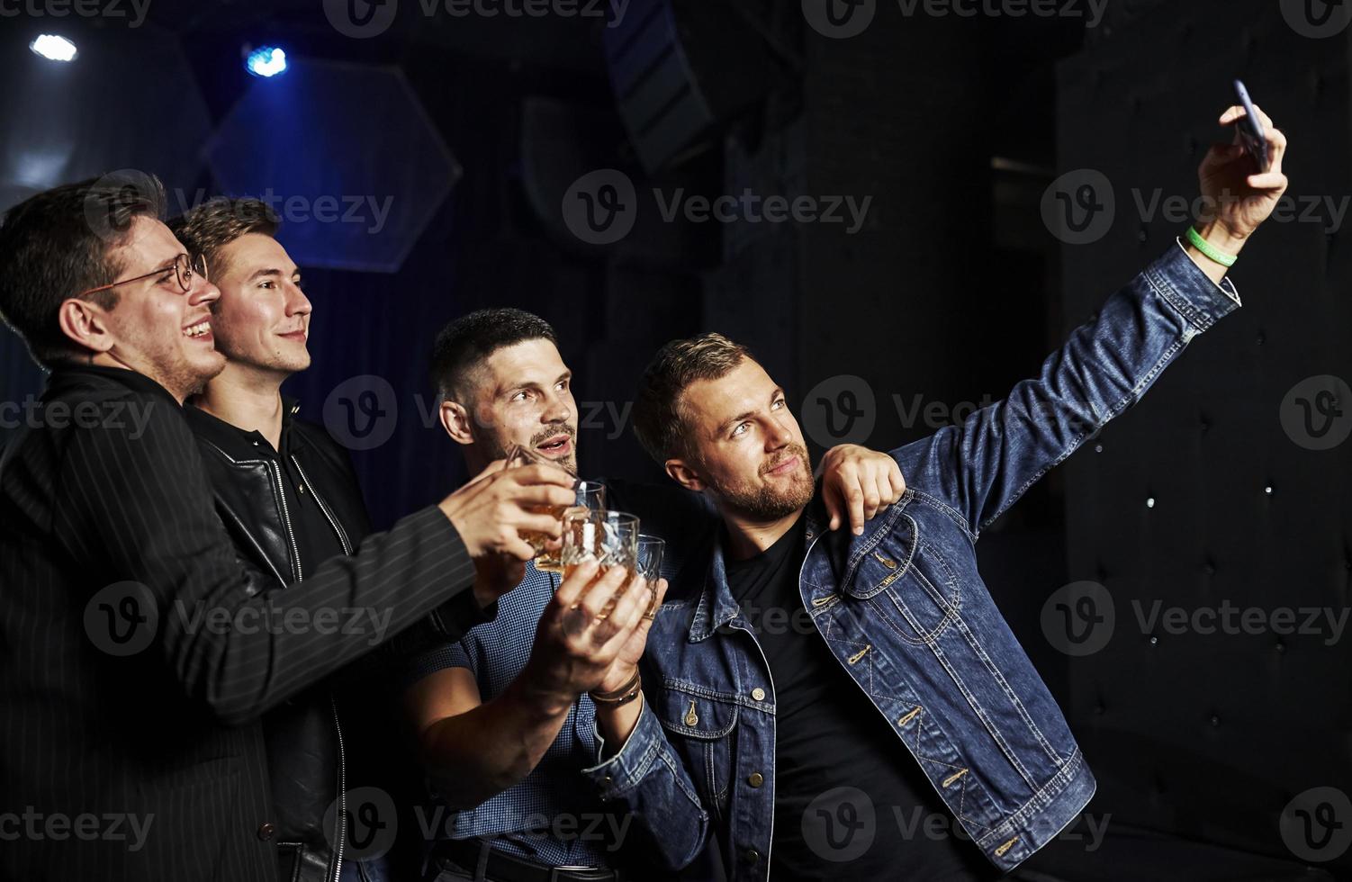 Die Leute haben Spaß im Nachtclub. mit Alkohol in den Händen foto