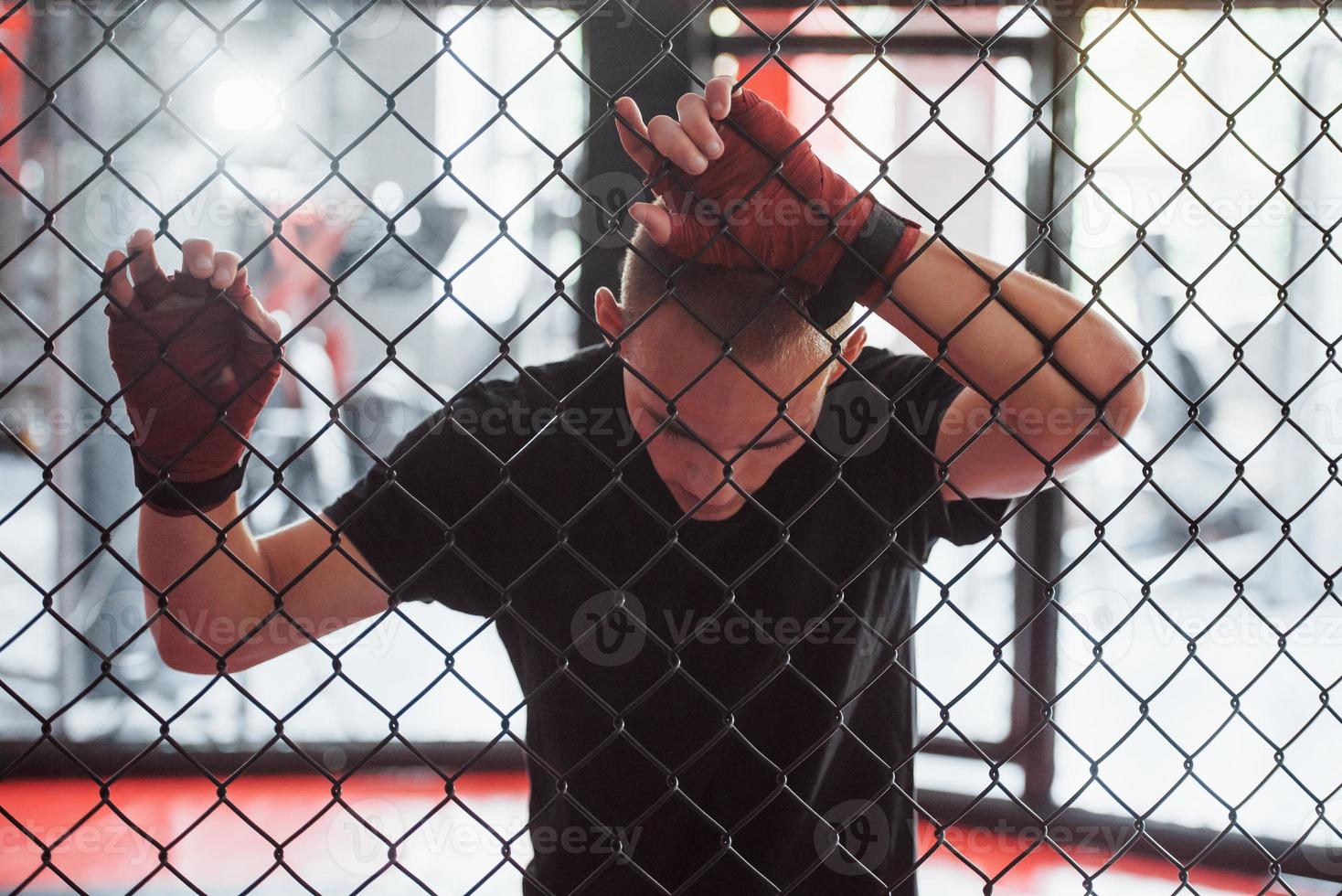 eine Pause machen. sportler am boxring haben übung. an den Zaun gelehnt foto