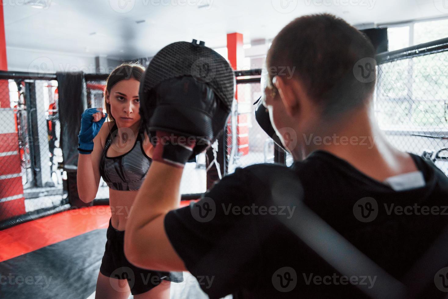 hinter dem Zaun. sportliche Jugendliche beim Sparring am Boxring foto