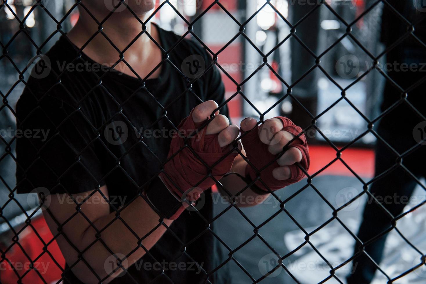 eine Pause machen. sportler am boxring haben übung. an den Zaun gelehnt foto