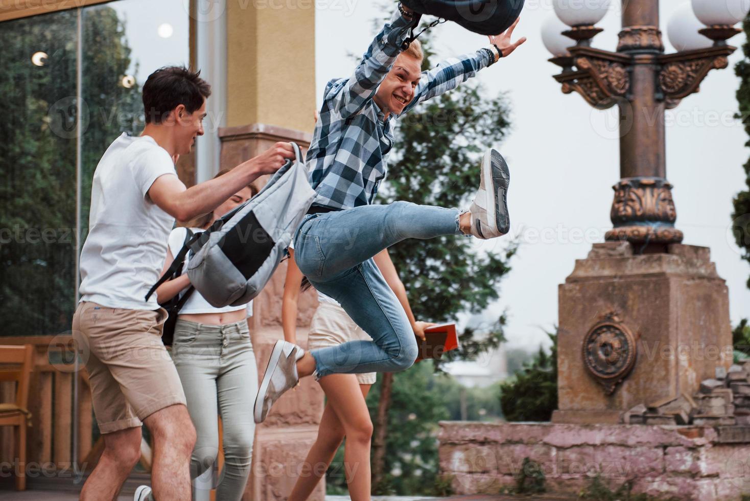 Spaß haben. vier junge studenten in lässiger kleidung treffen sich an einem regnerischen tag foto