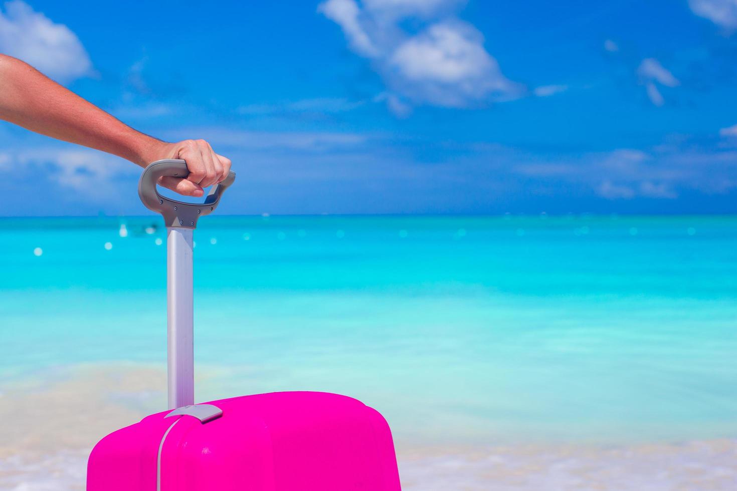 Nahaufnahme einer Person mit einem Koffer am Strand foto