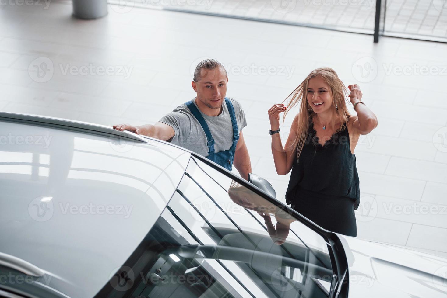 lächeln und Spaß haben. Ergebnisse der Reparatur. selbstbewusster Mann, der zeigt, welche Art von Schaden ihr Auto erlitten hat foto