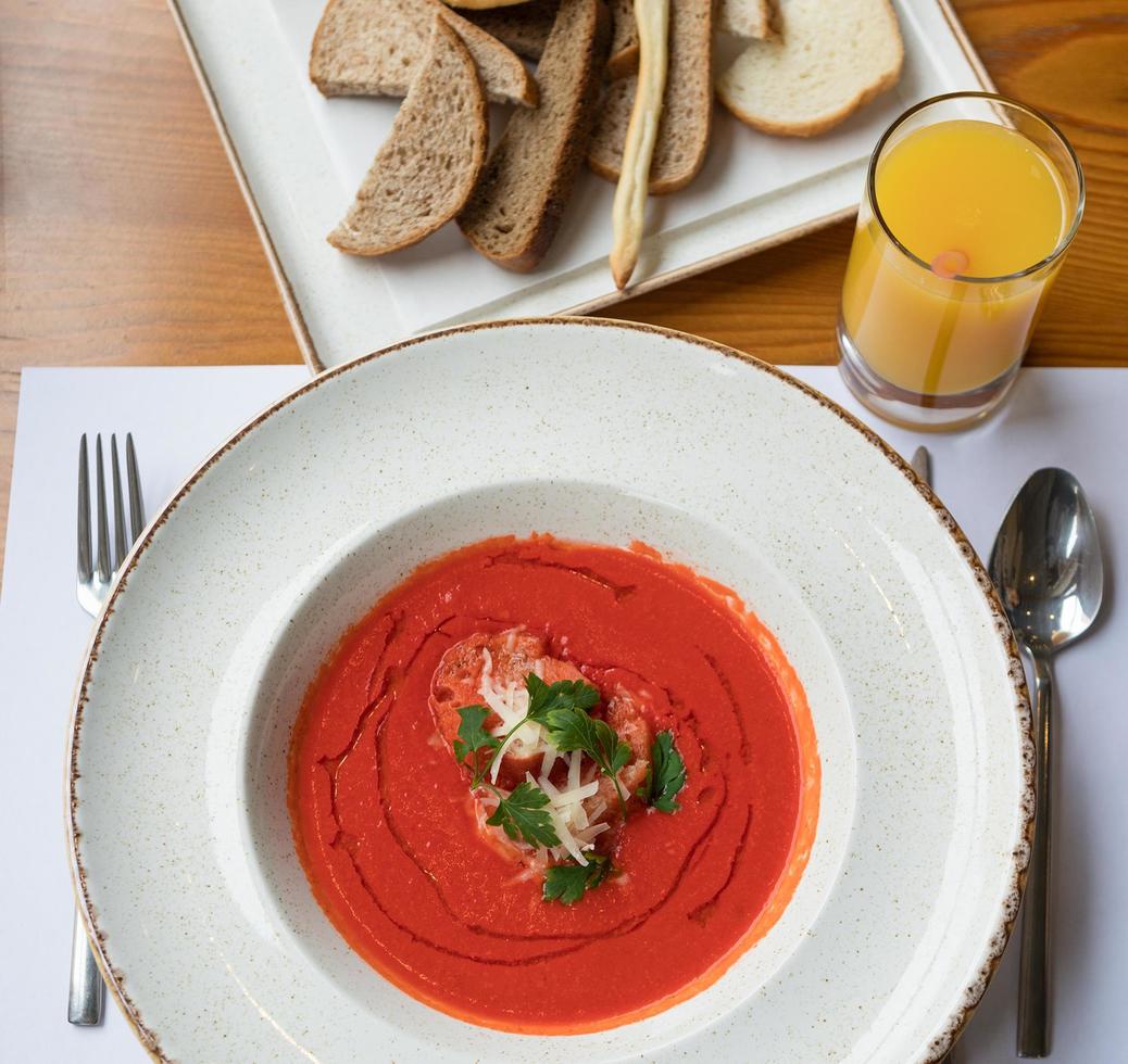 Tomatensuppe mit Orangensaft und Brot foto