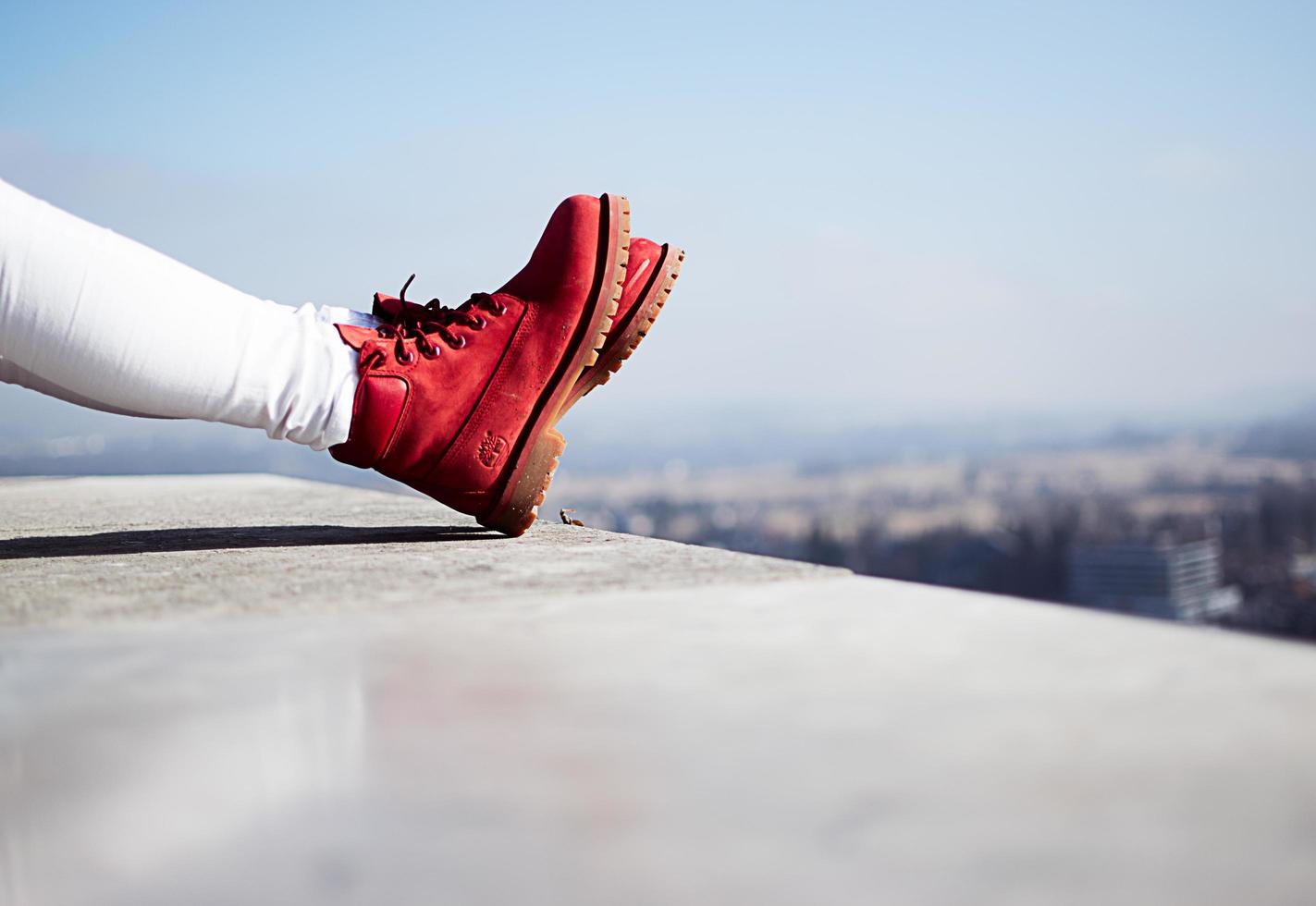 Slowenien, 2020 - Person, die rote Stiefel auf einem Dach in einer Stadt trägt foto