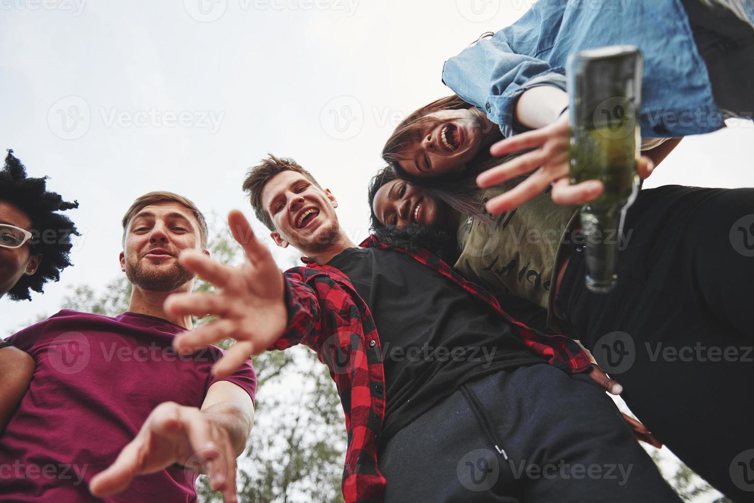 Hallo. Multiethnische Gruppe von Menschen feiern im Freien. Ansicht von unten foto