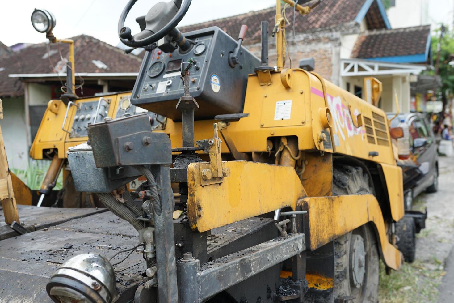 Asphaltfertiger, vorderes Detail einer am Straßenrand geparkten Straßenbaumaschine foto