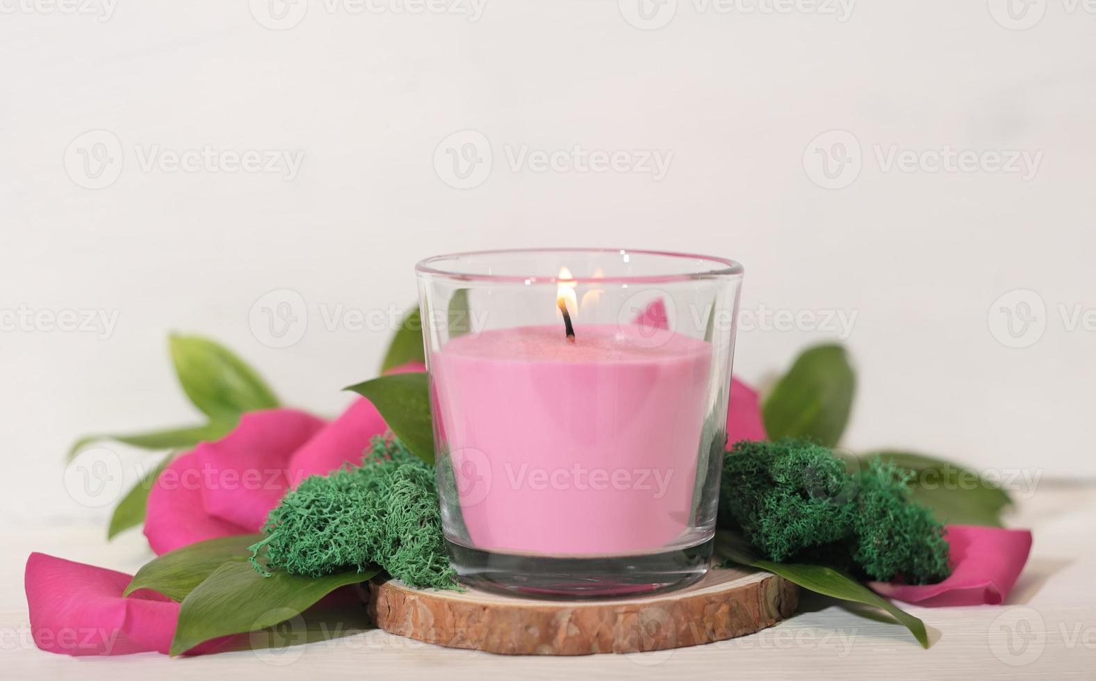 blumige duftende brennende kerze mit grünen blättern, moos und blütenblättern. Raumdüfte, gemütliches Wohnambiente, romantische Dekoration für den Valentinstag. foto