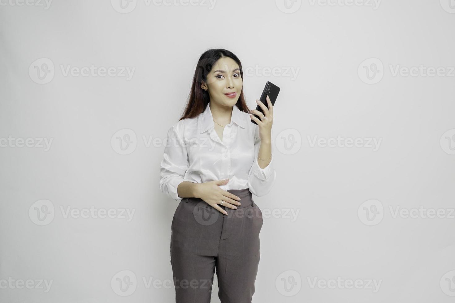 Foto einer hungrigen aufgeregten jungen Frau, die ihr Telefon hält und sich fragt, was sie leckeres Essen einzeln auf weißem Farbhintergrund bestellen soll