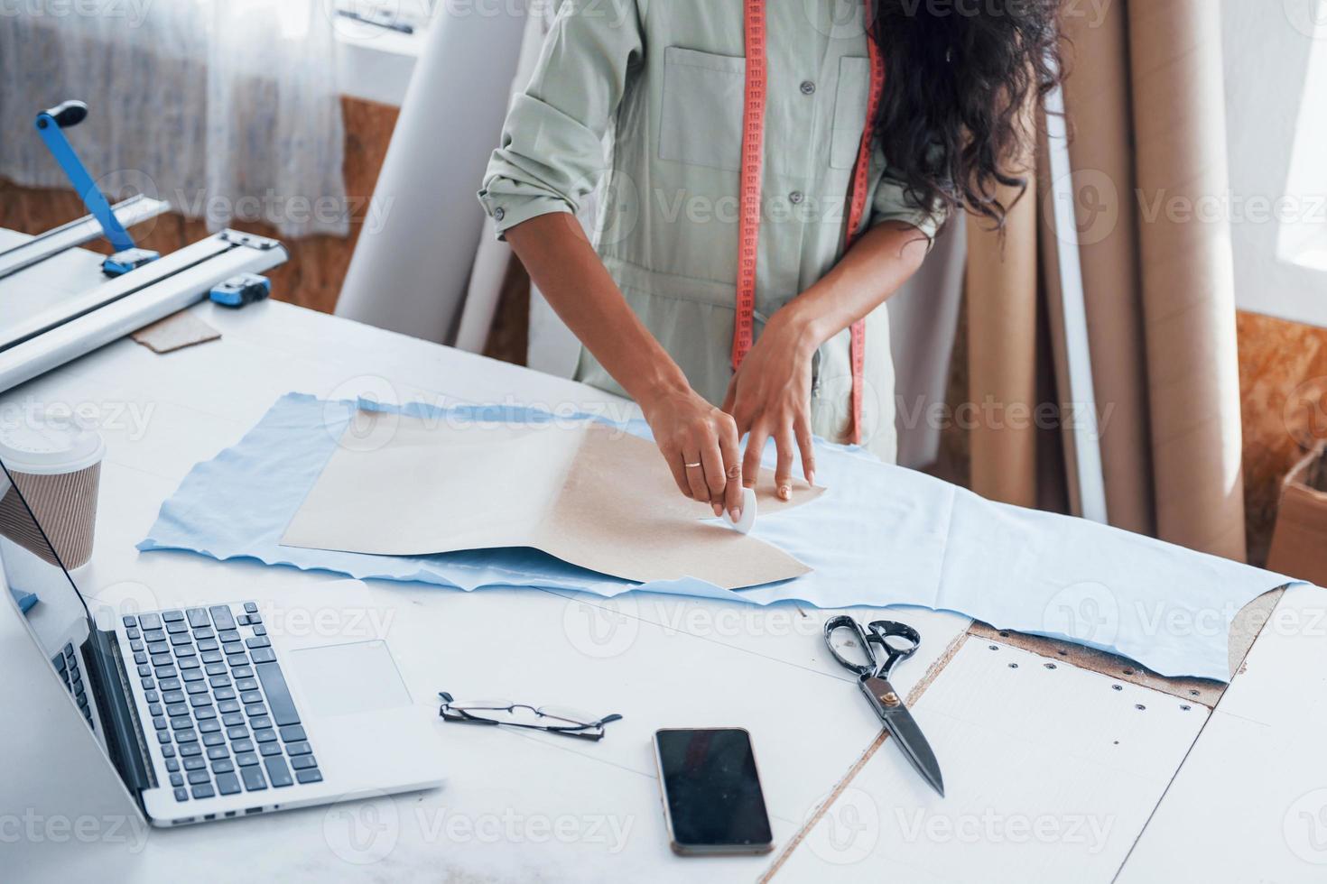 mit Tuch beschäftigt. schöne arbeiterin ist in der nähfabrik foto