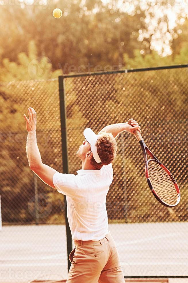 junger tennisspieler in sportlicher kleidung ist draußen auf dem platz foto