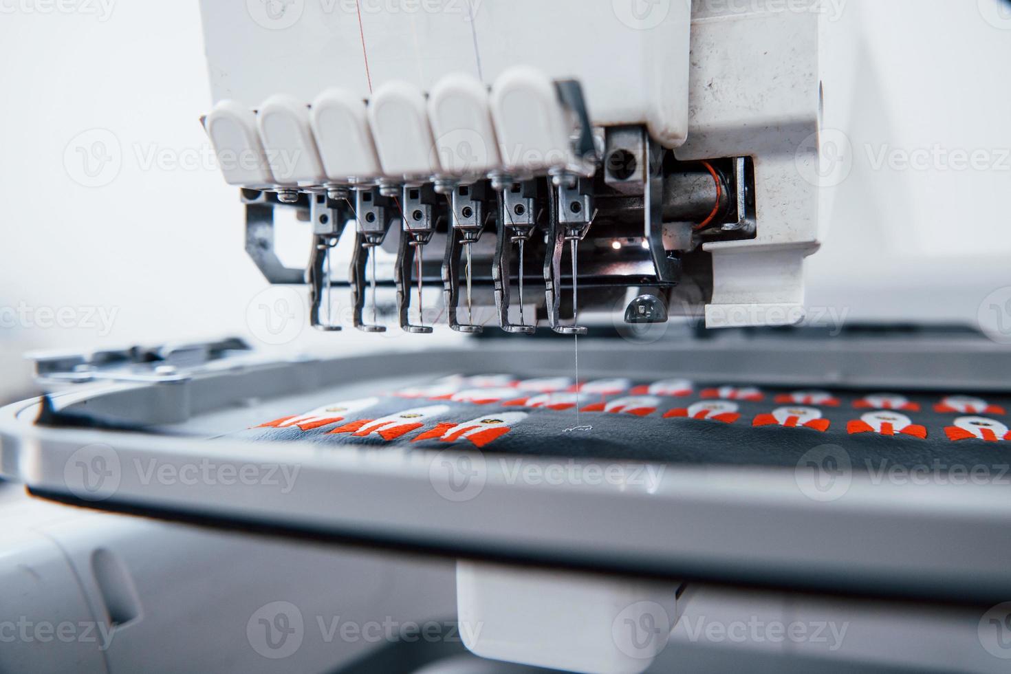 Raketenbilder machen. Nahaufnahme der weißen automatischen Nähmaschine im Werk in Aktion foto