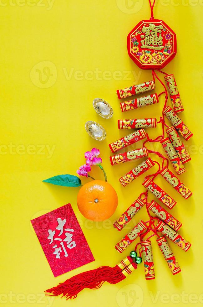 Feuerwerkskörper für das chinesische Neujahrsschmuckwort bedeutet Reichtum, Segen mit Goldbarren, orange und rotes Umschlagpaket oder ang bao-Wort bedeutet Vorzeichen auf gelbem Hintergrund. foto