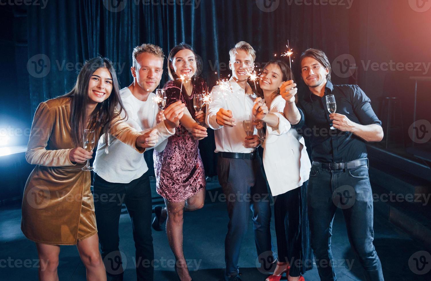 gruppe von freunden in festlicher kleidung feiern zusammen drinnen foto