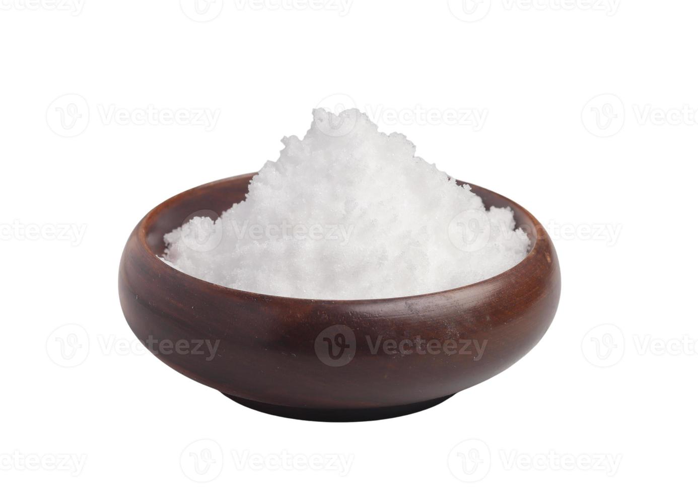 weißes Salz in einem Holzbecher auf weißem Hintergrund foto