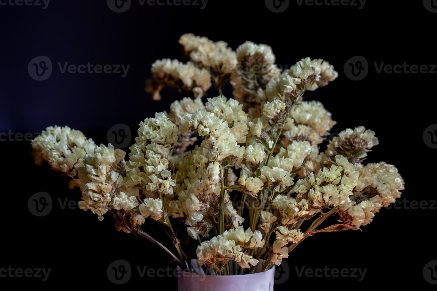 Getrocknete gelbe Statice-Blüten in einer Vase foto