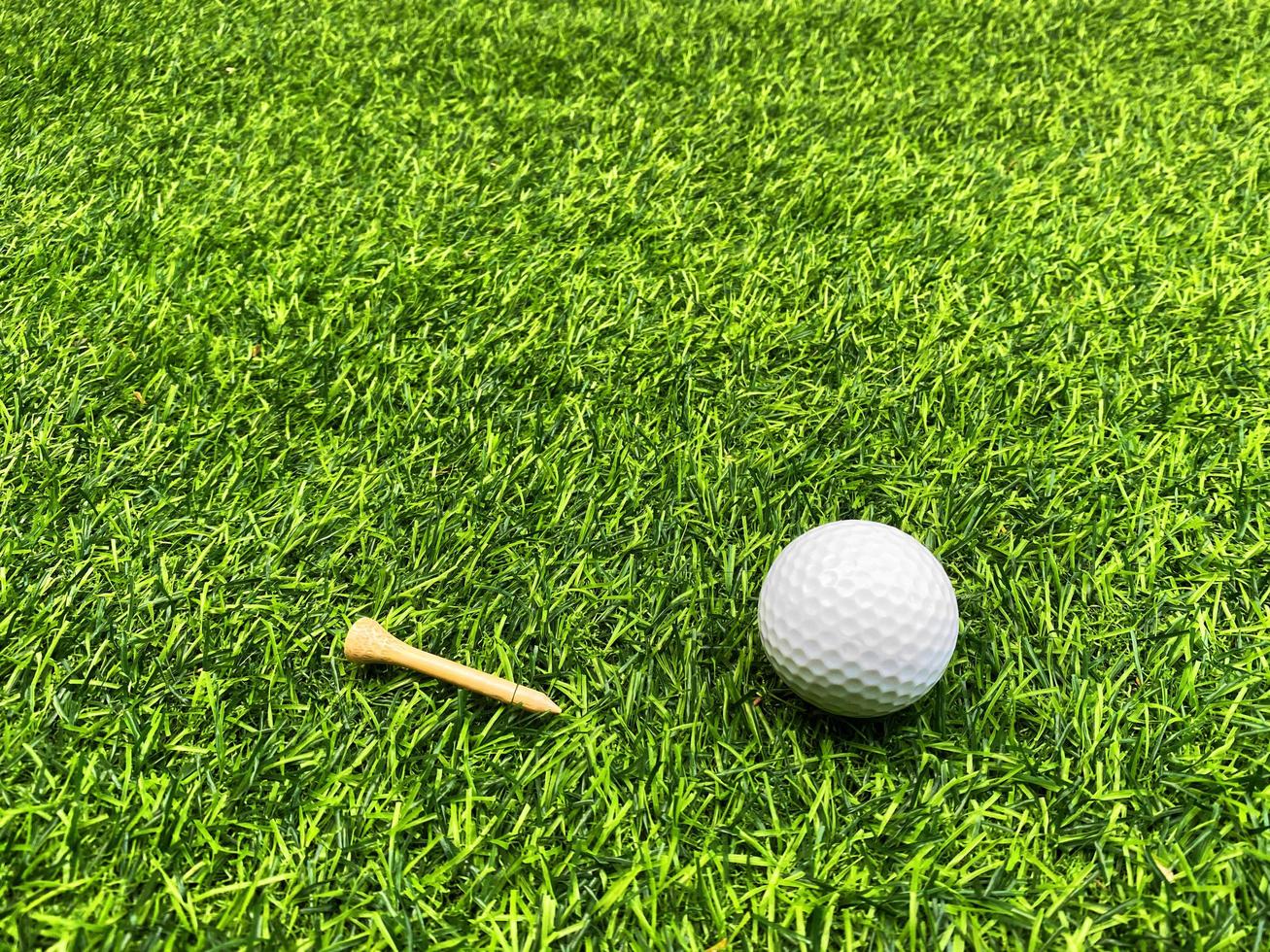 golfball nah oben auf grünem gras auf unscharfer schöner landschaft des golfhintergrundes.konzept internationaler sport, der auf präzisionsfähigkeiten zur gesundheitsentspannung angewiesen ist. foto