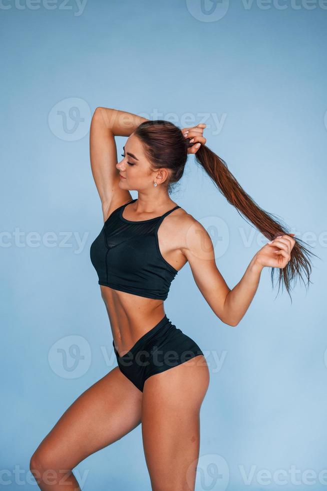 junge Frau mit schlankem Körpertyp vor blauem Hintergrund isoliert foto