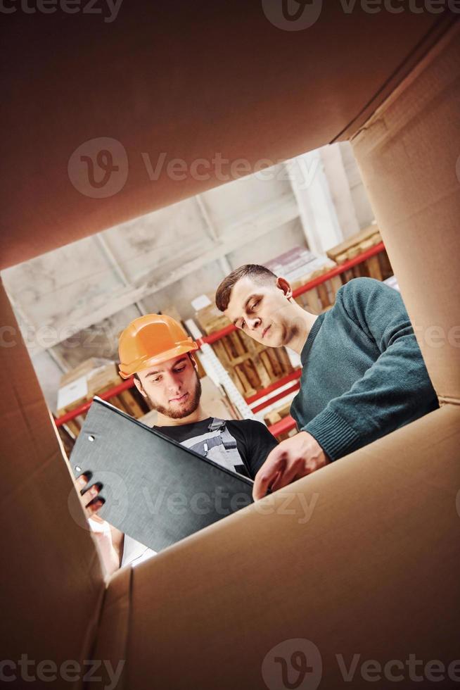 Blick aus dem Inneren der Box. Zwei Personen mit Notizblock haben eine Arbeit foto