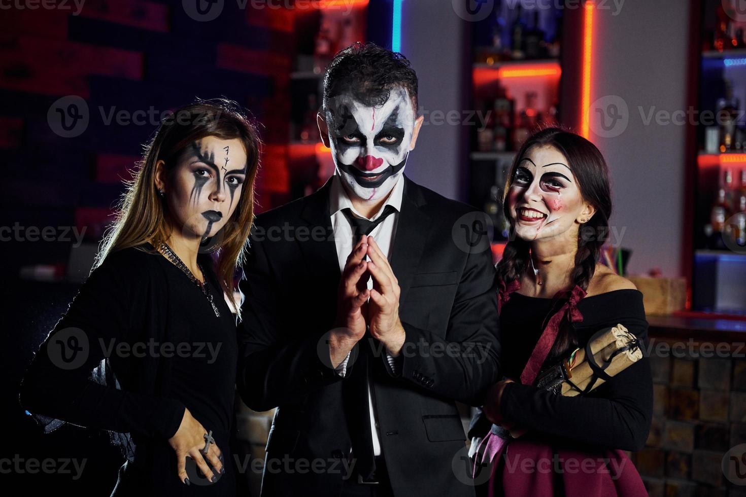 Freunde werden auf der Motto-Halloween-Party in schaurig geschminkten Kostümen Spaß haben und gemeinsam vor der Kamera posieren foto