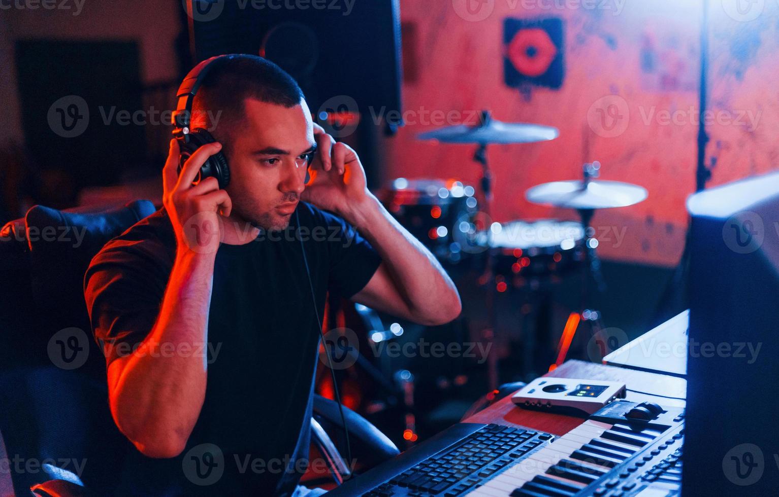 toningenieur mit kopfhörern, der musik drinnen im studio bearbeitet und mischt foto