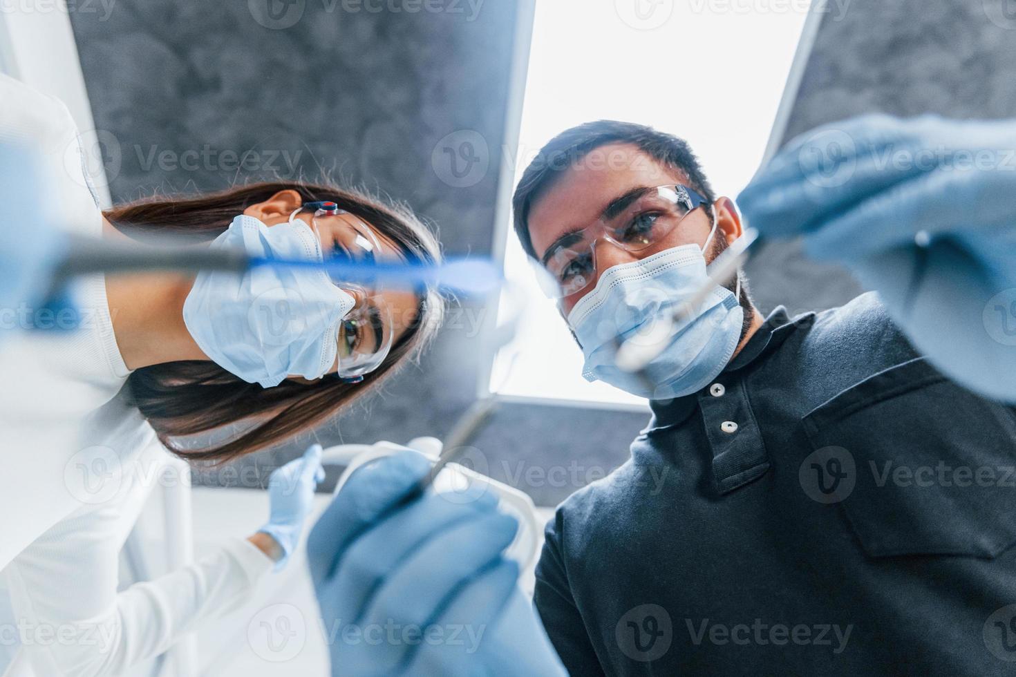 männliche und weibliche zahnärzte, die gemeinsam im büro arbeiten. Erste-Person-Ansicht foto