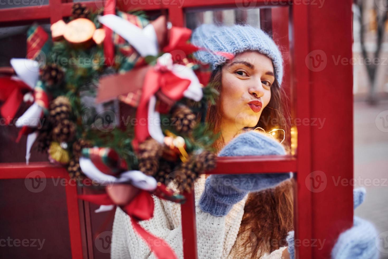 frau in warmer kleidung hat spaß in der telefonstation. schönes Mädchen foto