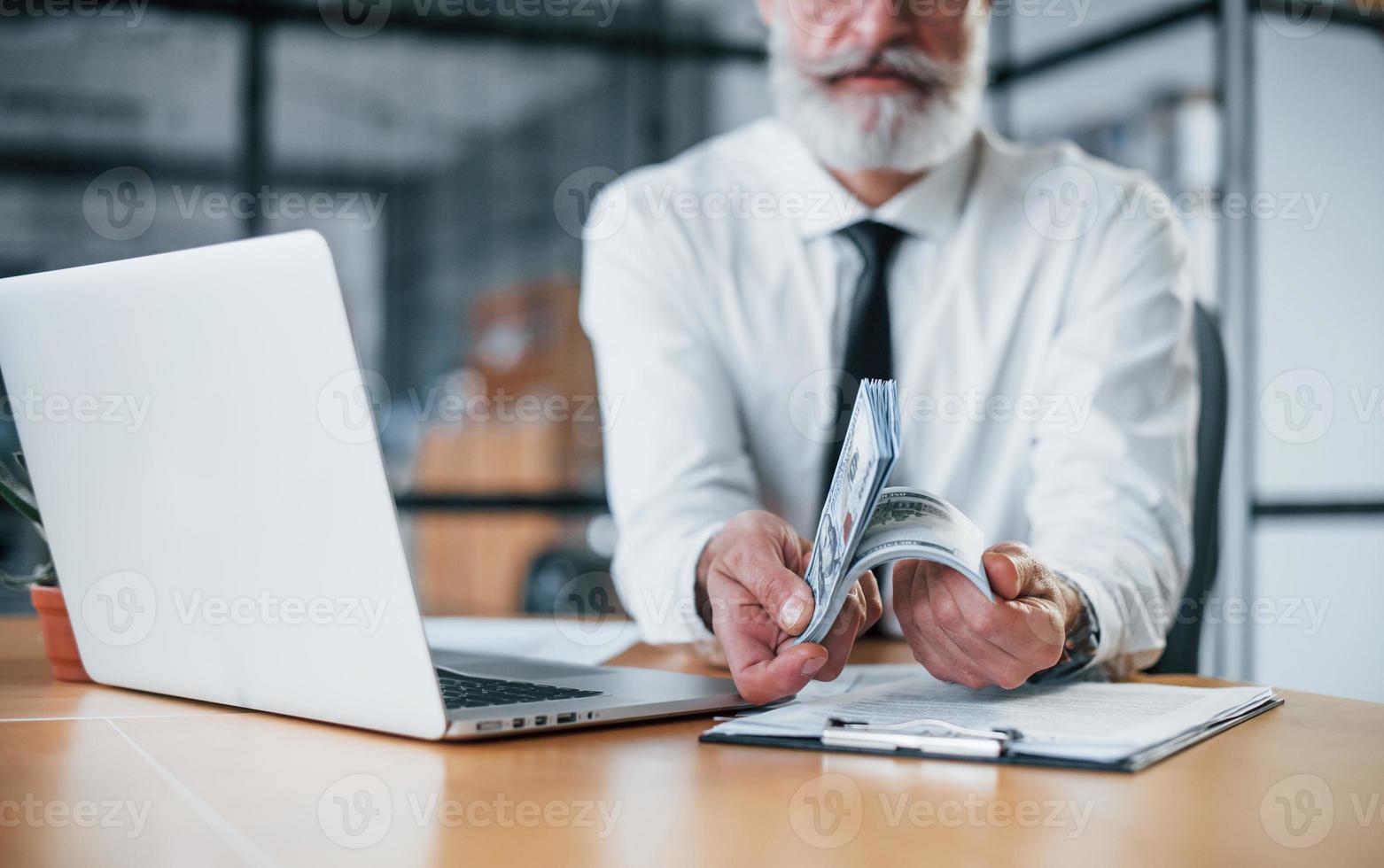 Nahaufnahme eines Geschäftsmannes, der im Büro Geld in den Händen hält foto